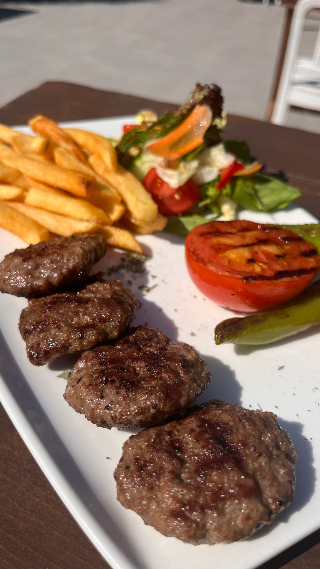 Izgara köfte, patates kızartması ve közlenmiş sebzeli tabak
