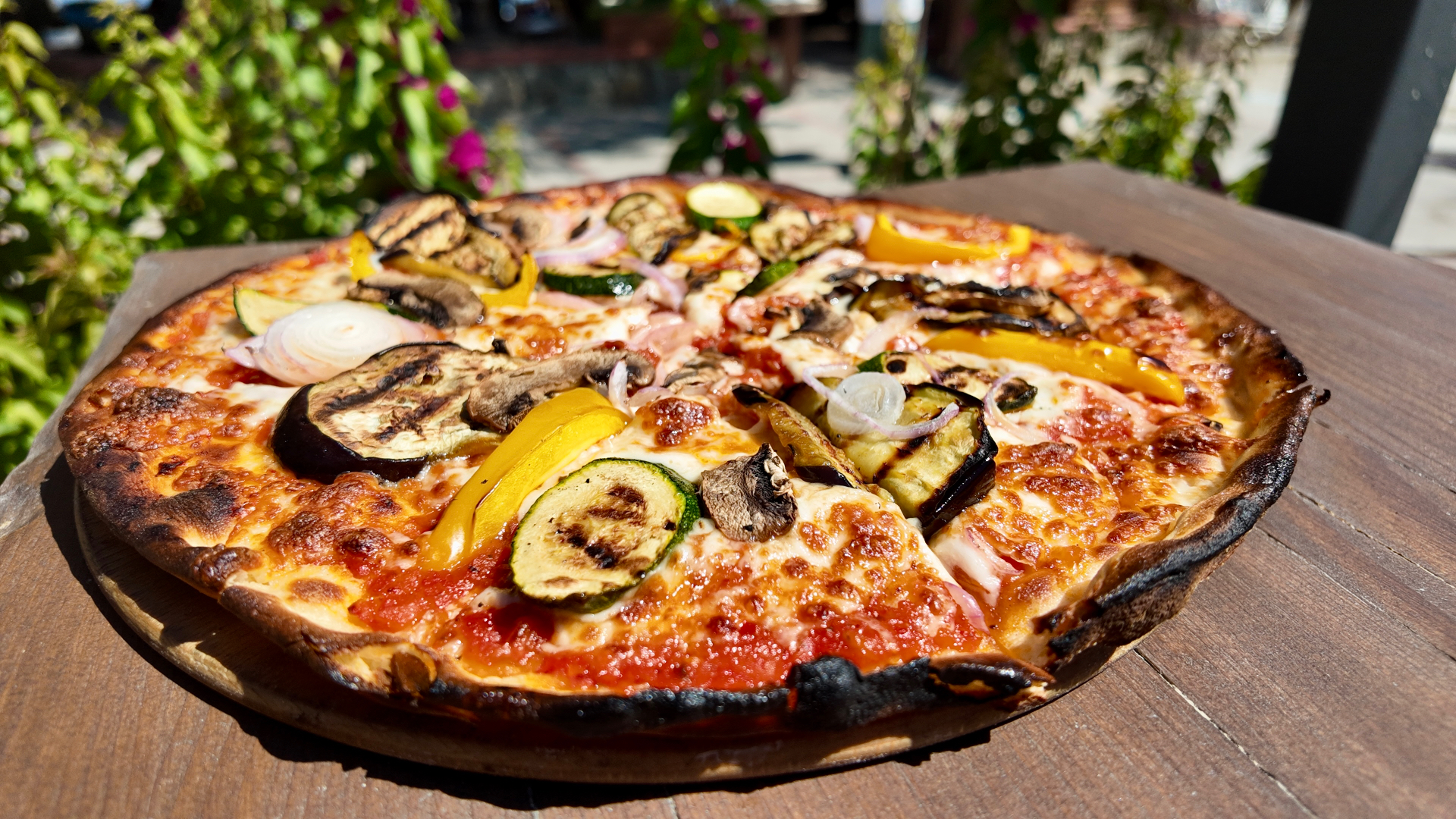 Sebzeli odun fırın pizzası, begonviller önünde