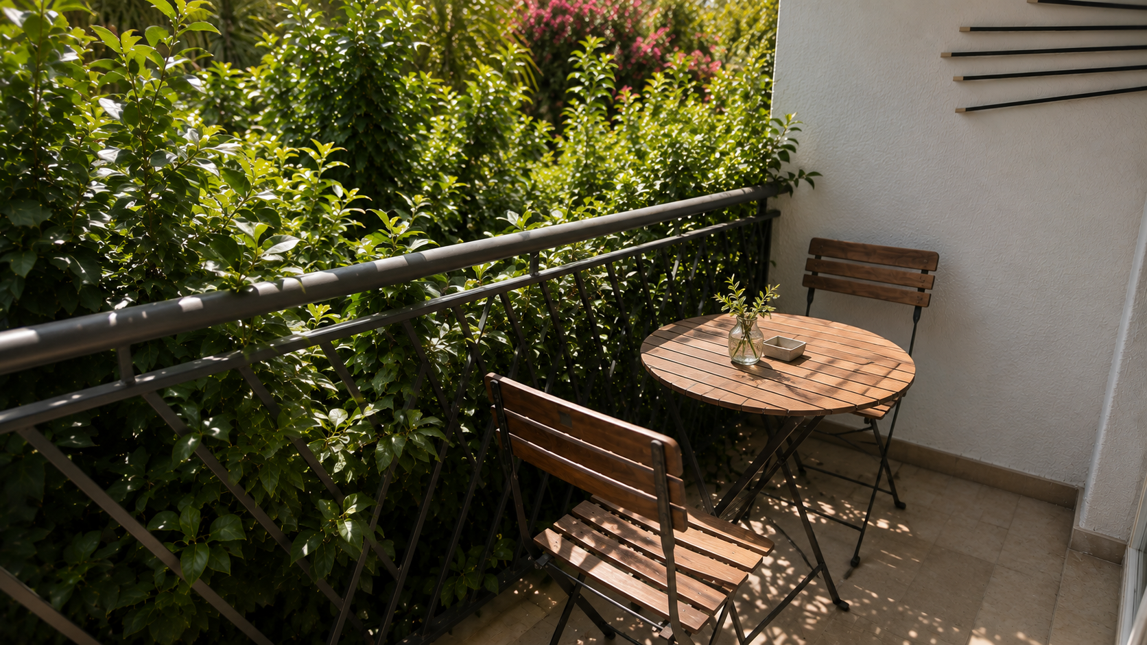 Private balcony with bistro table and greenery
